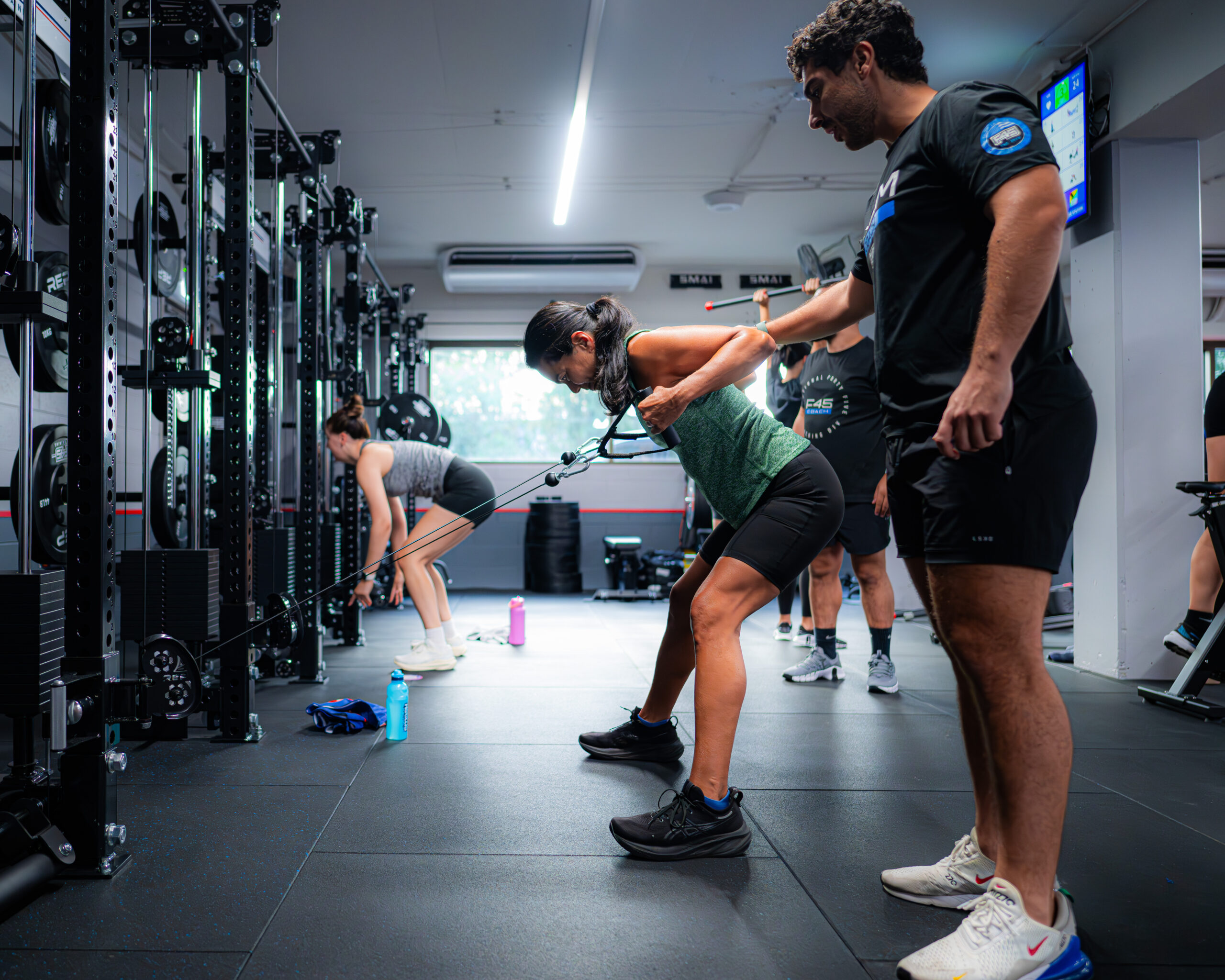 Group training session at F45 DTLA HIIT gym with members doing cardio and strength exercises
